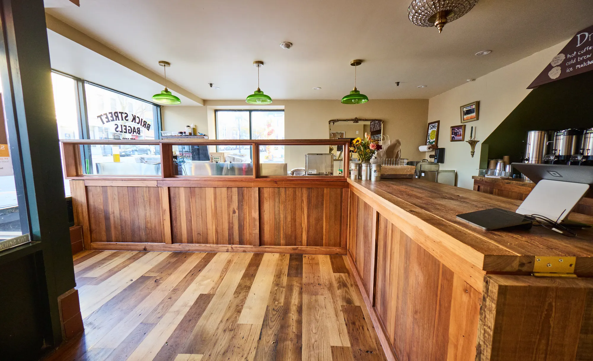 The counter running along the front windows, the sign reversed in the glass and green pendants above.