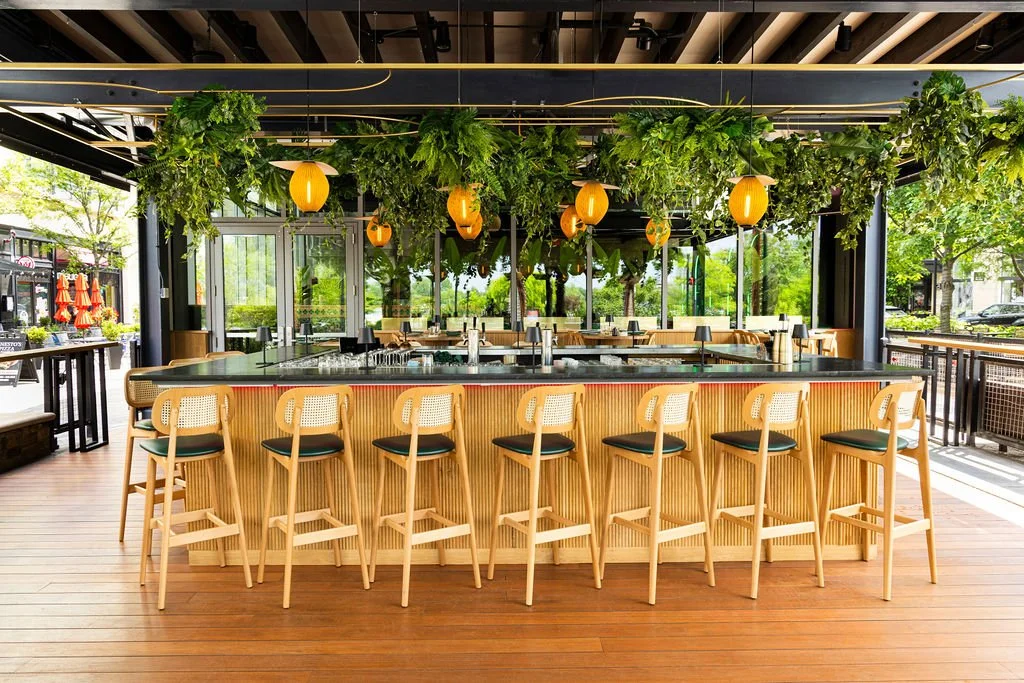 TA second bar on a timber deck, under hanging greenery and lanterns.