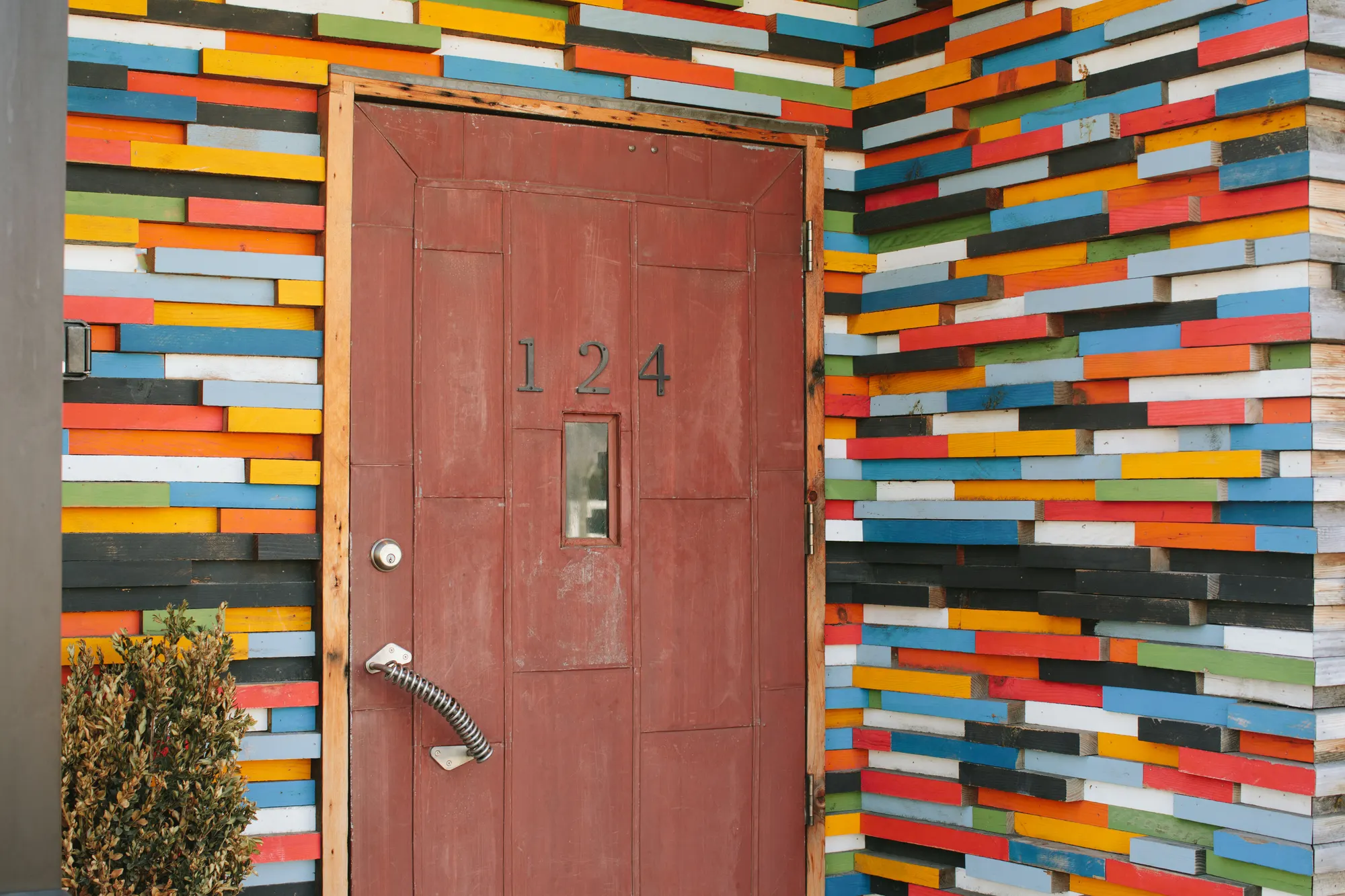 Offcuts in a dozen colours, laid around a plain painted door.
