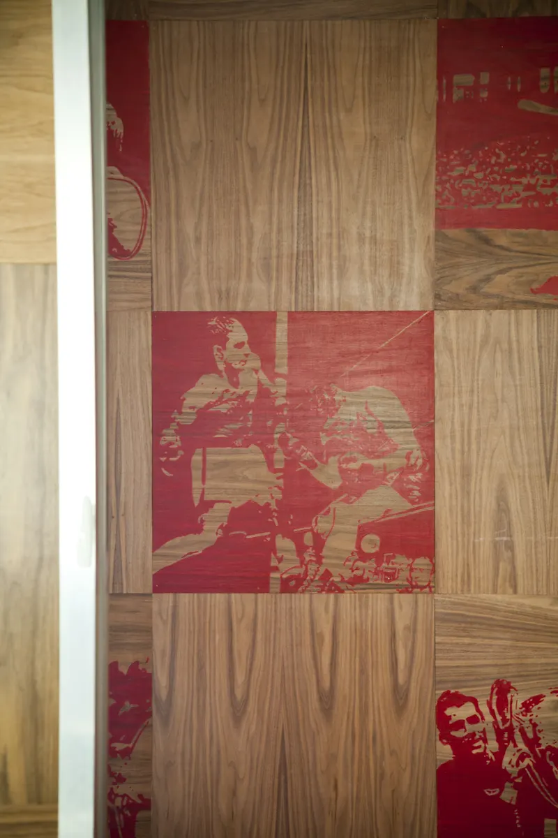 Red-printed boxing photographs on timber panels, close up.