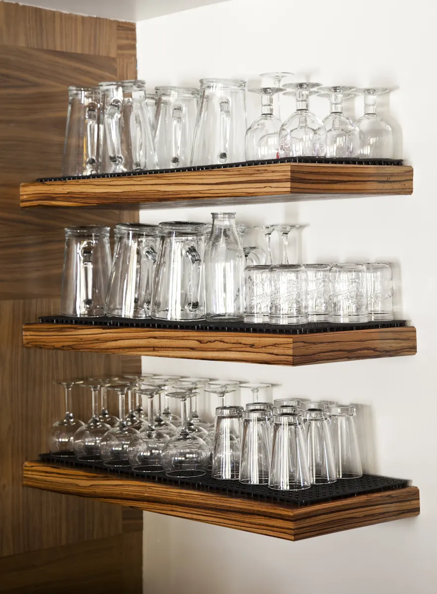 Glasses stacked on floating timber shelves.
