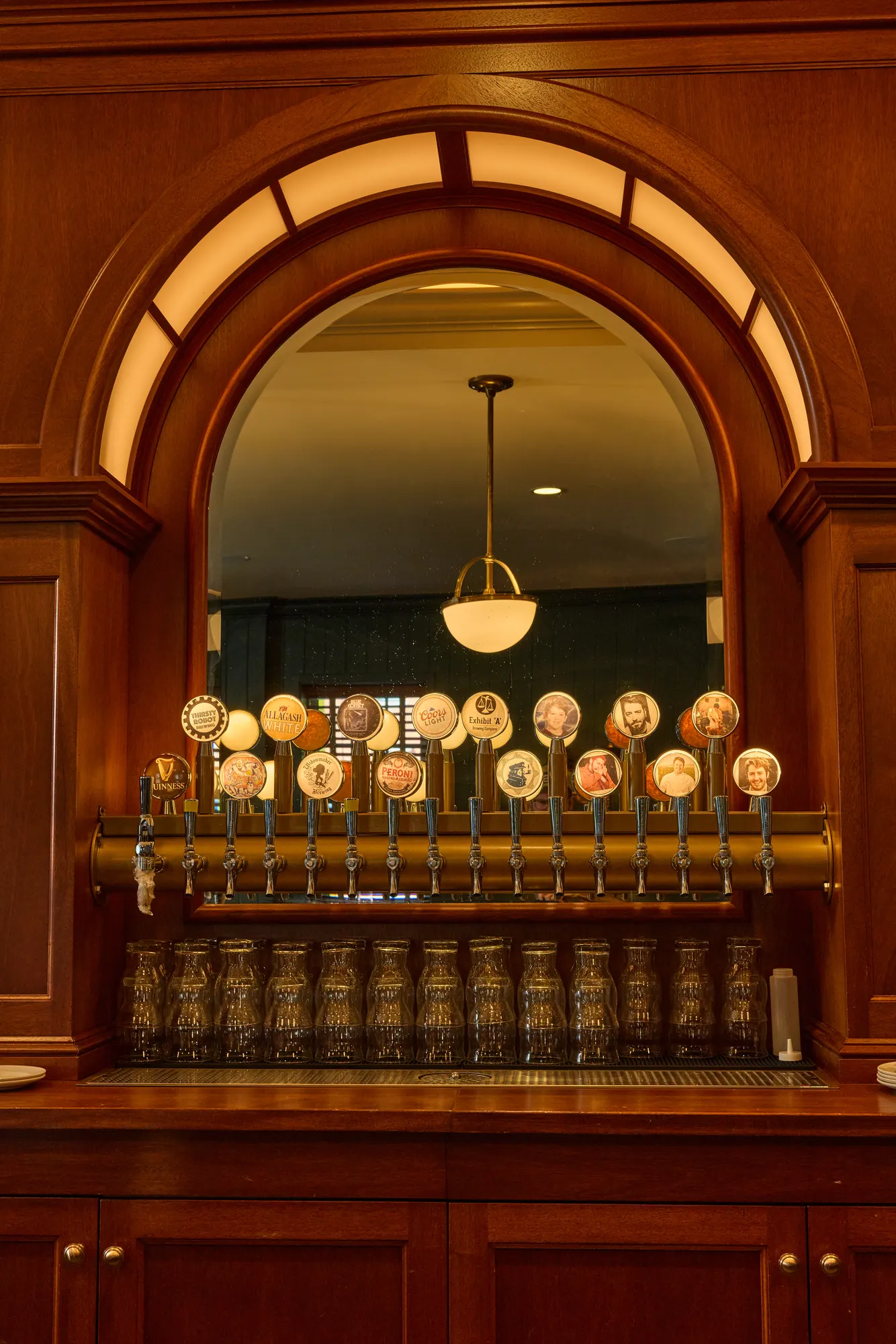 The taps at Puritan Tavern, a row of brass taps under a lit mahogany arch