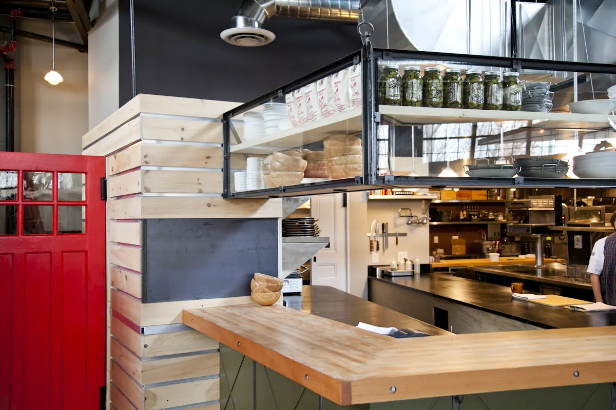 The kitchen open to the floor, behind a timber counter.