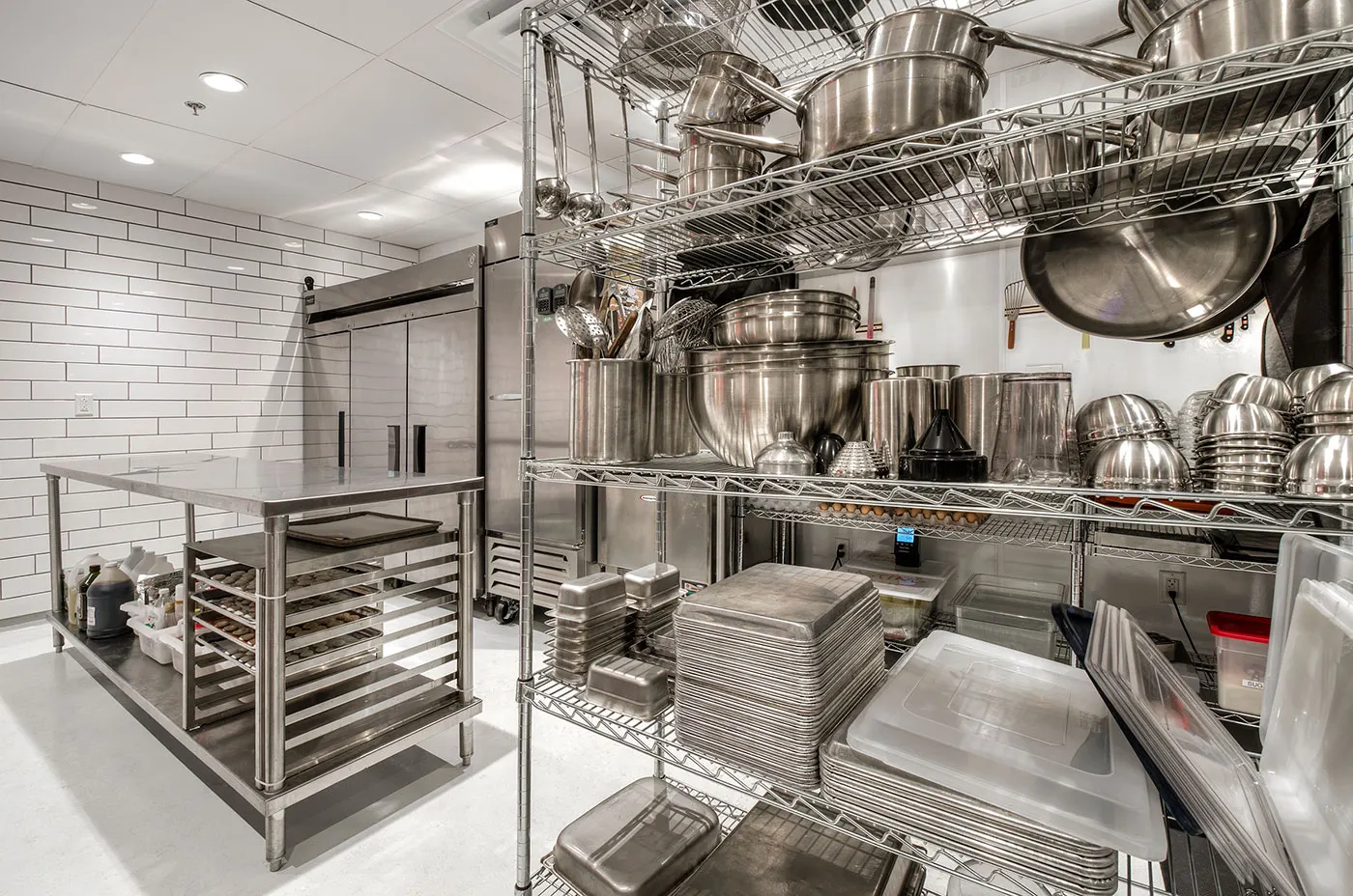 The working kitchen behind, in stainless steel.