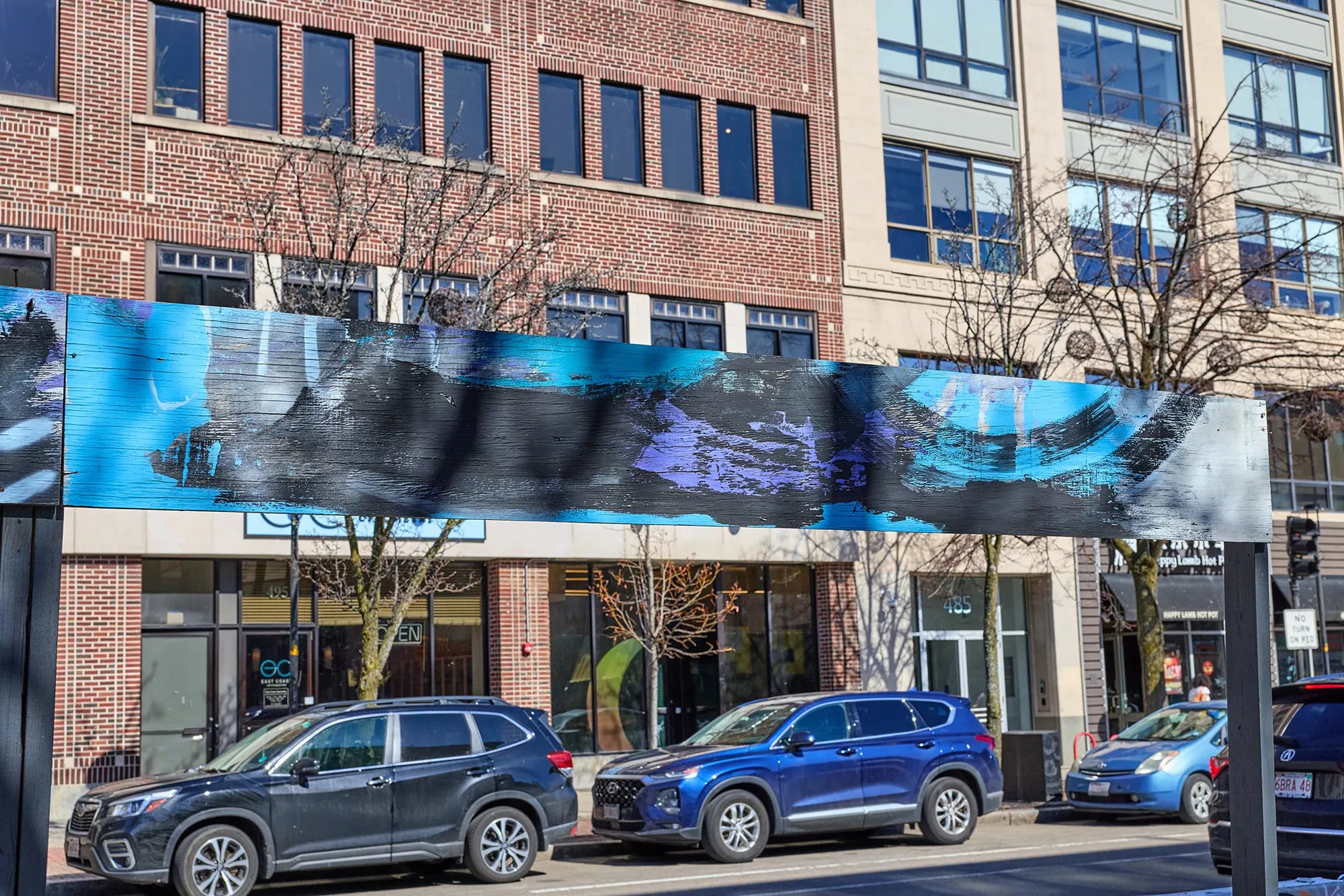 A painted sign board over the patio, facing the street.