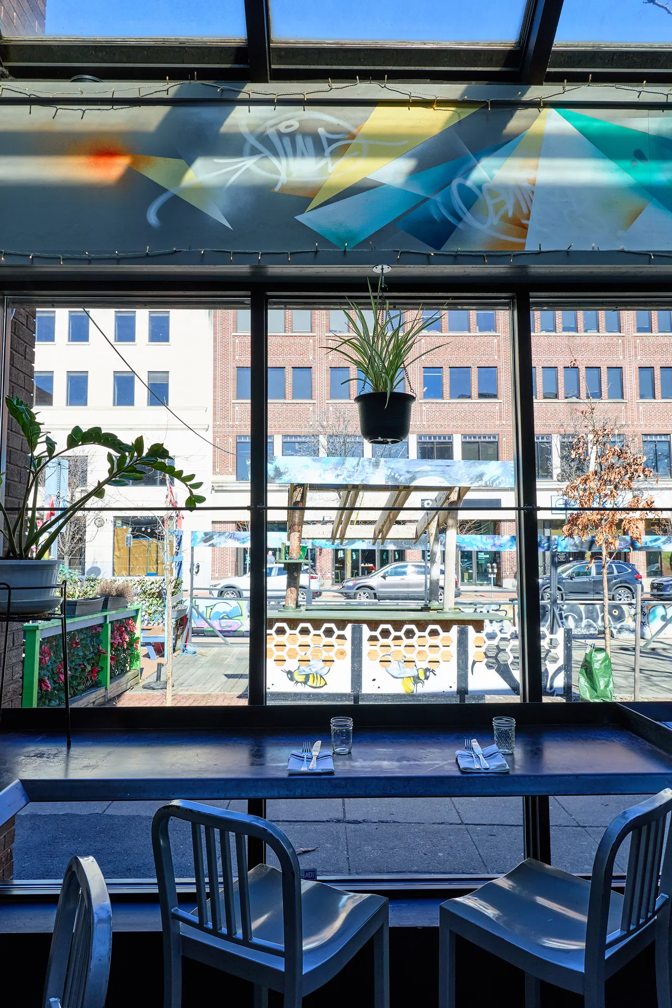 Chairs at a window table, looking out through the glass wall to the patio.