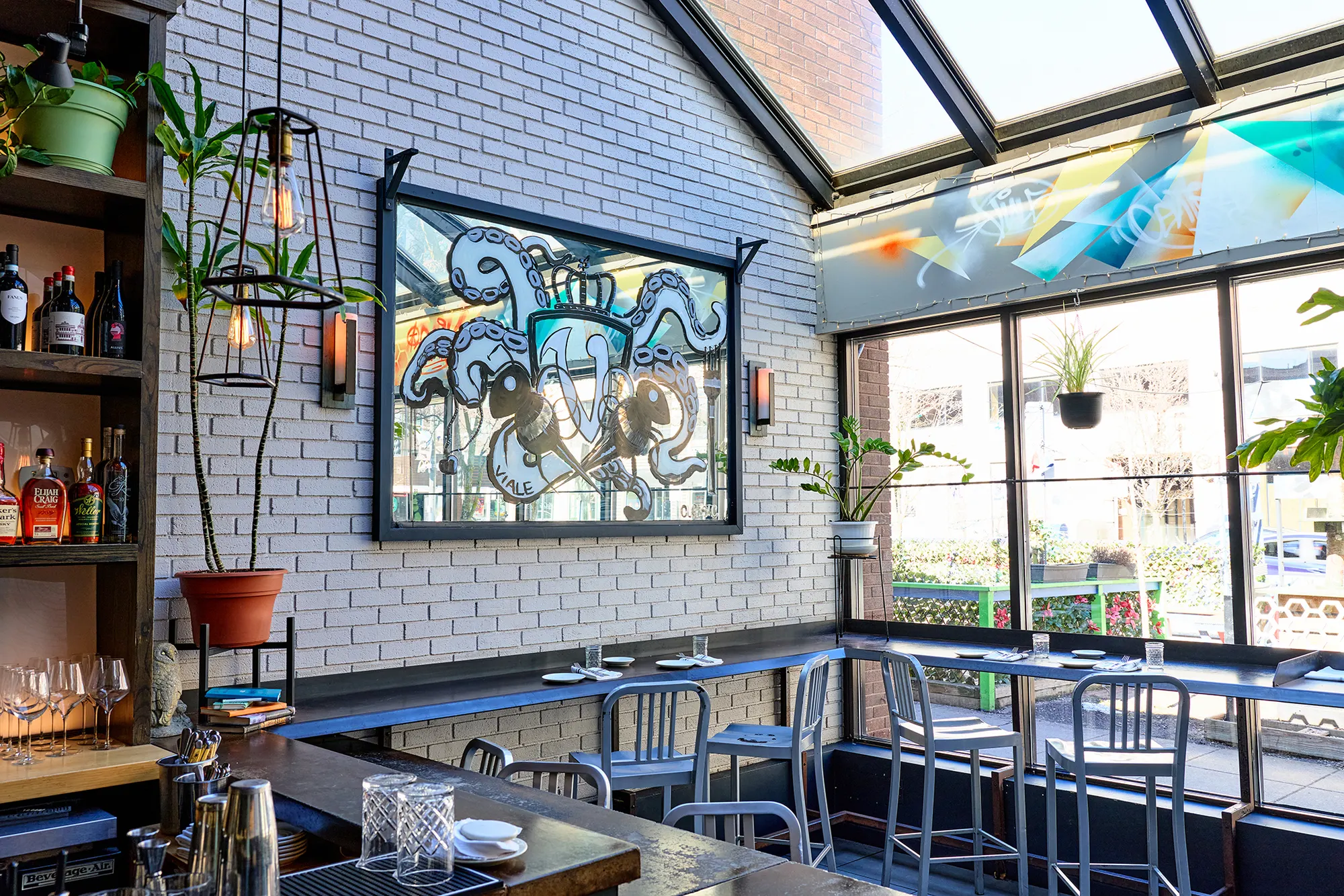 The glass-roofed room with its counter, stools and framed artwork.