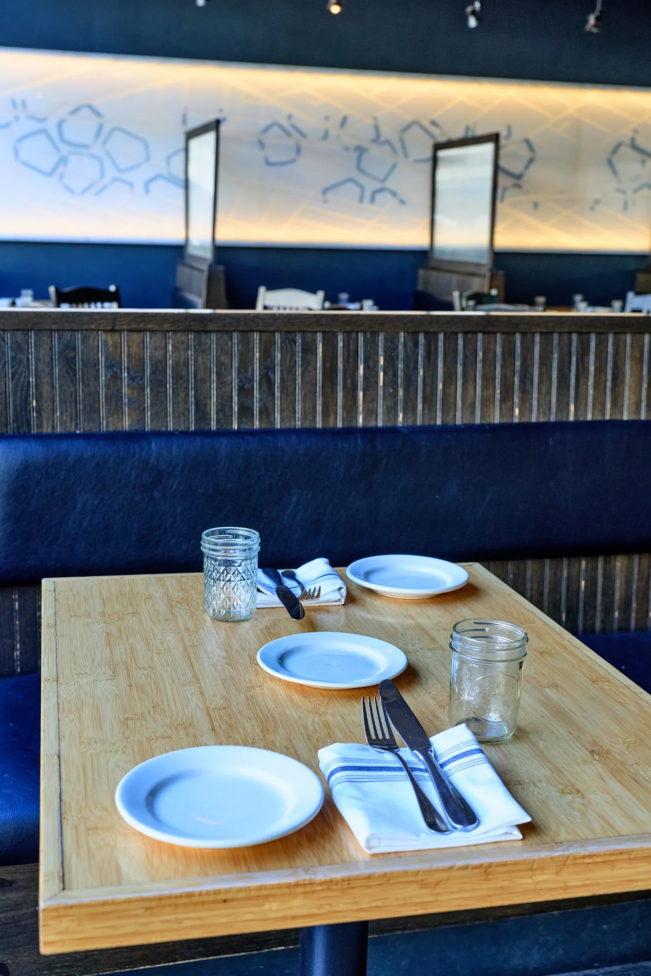 A bamboo table set for four in a navy booth.