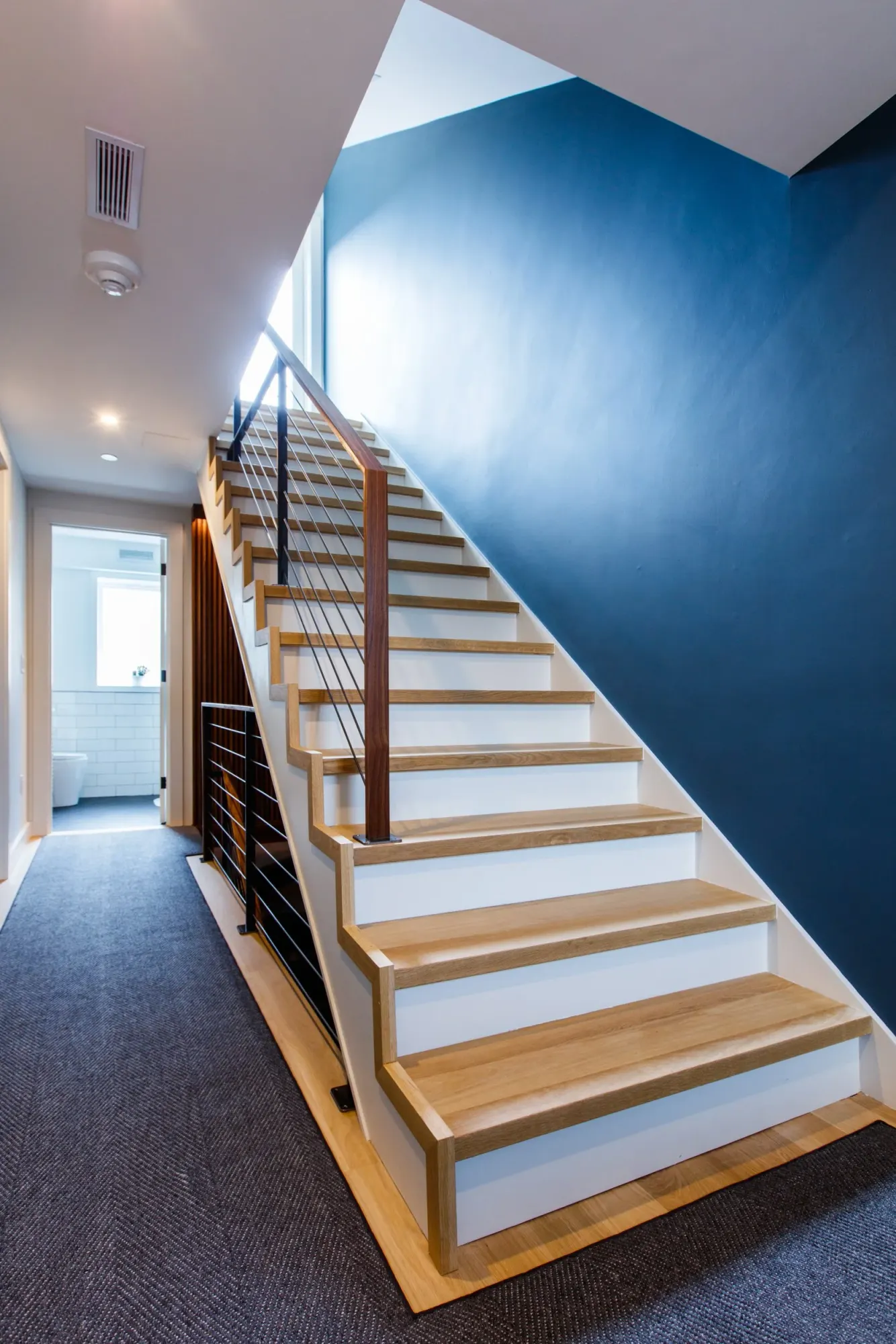 Timber treads against a deep blue wall, lit from above.