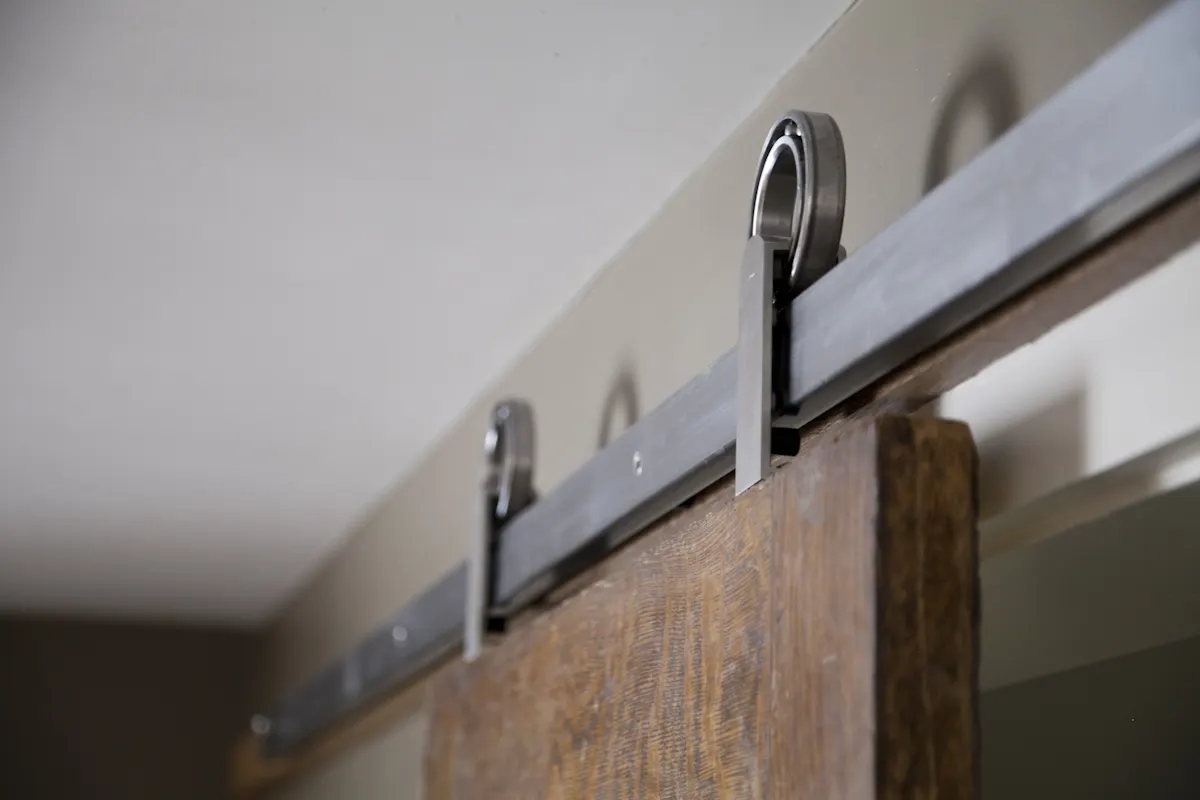 The steel track and rollers of the sliding door, close up.