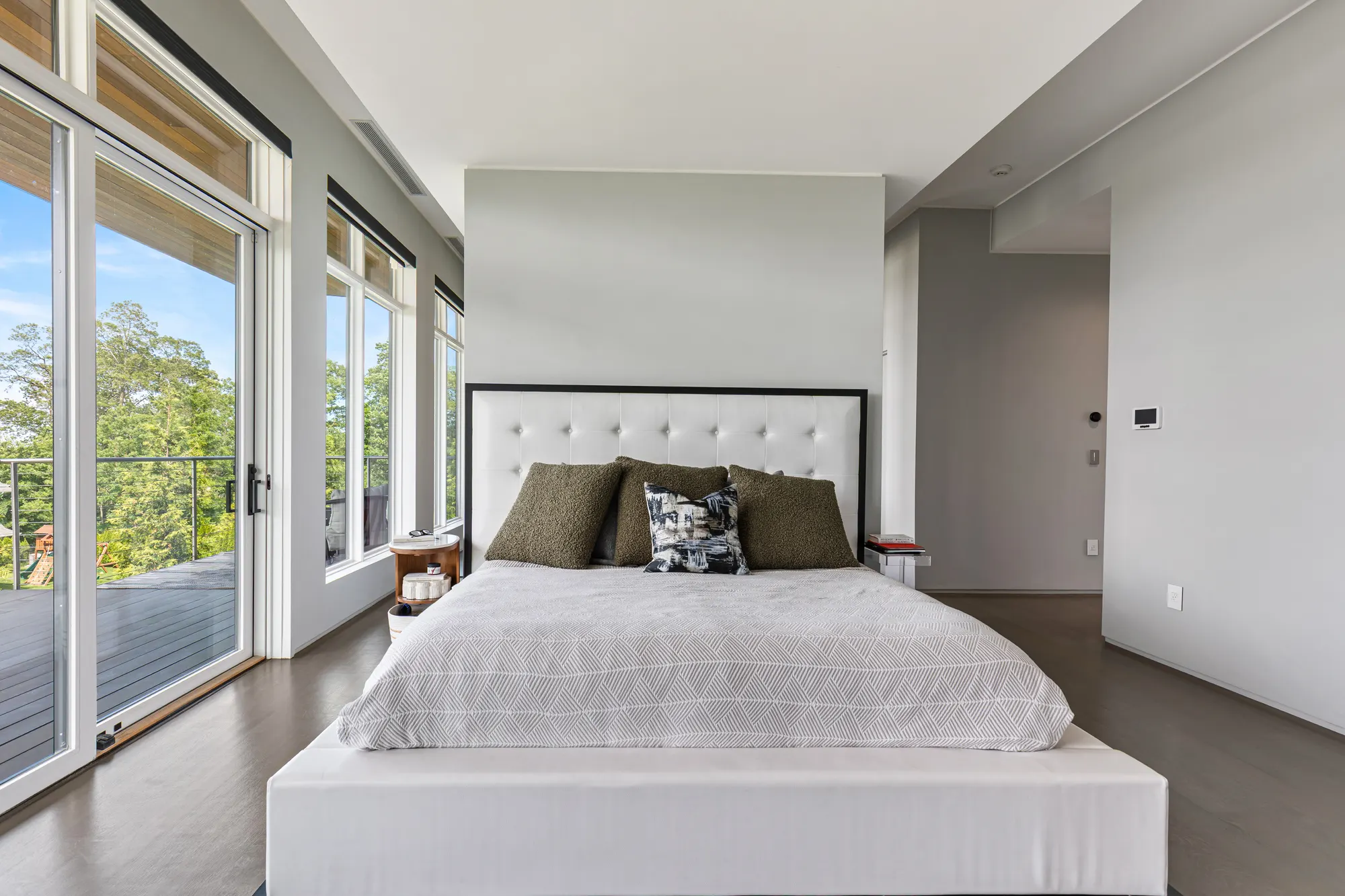 The bed in the middle of the room, glass doors to the deck along the left.