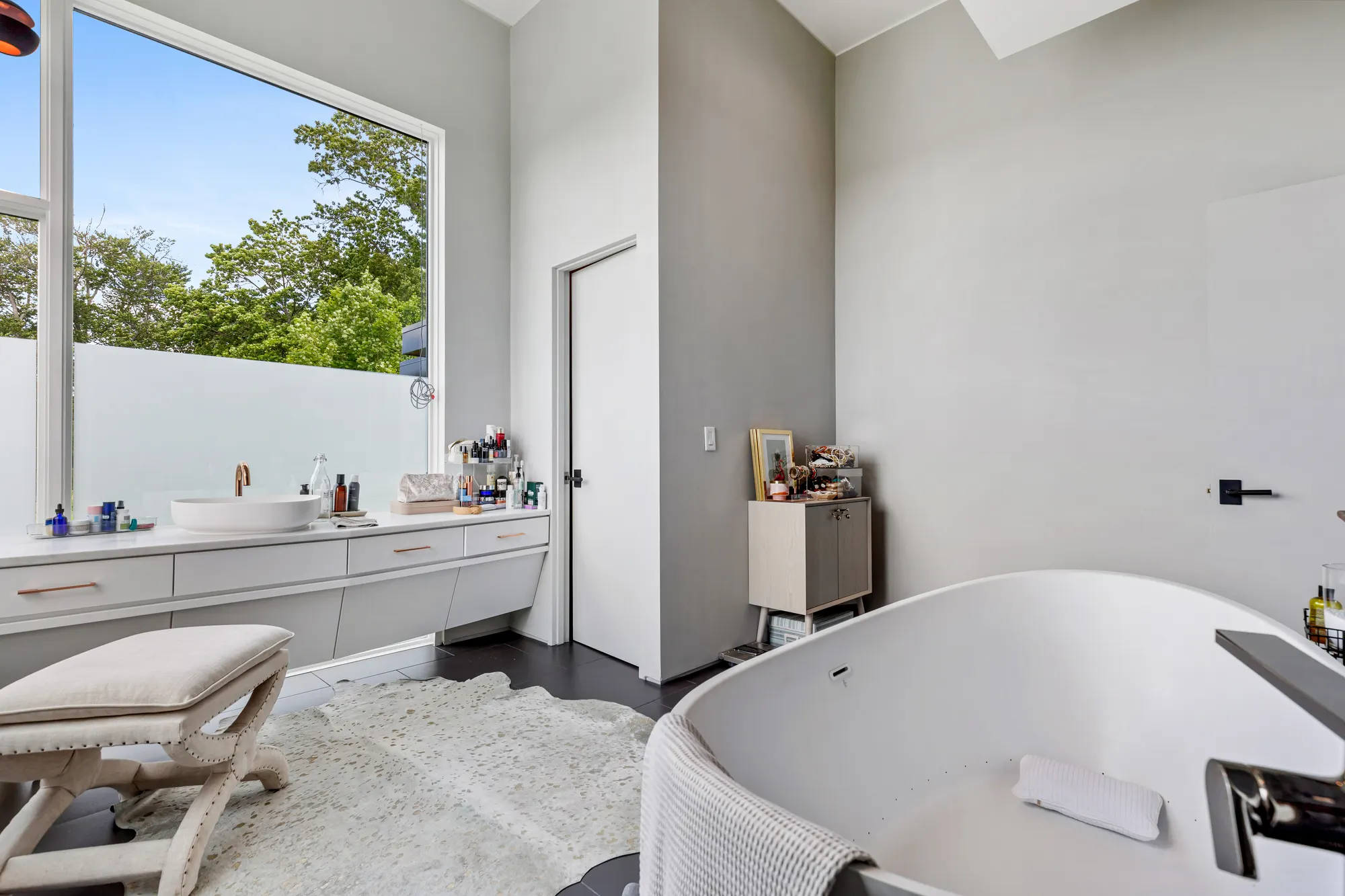 The vanity and window seen past the rim of the tub.