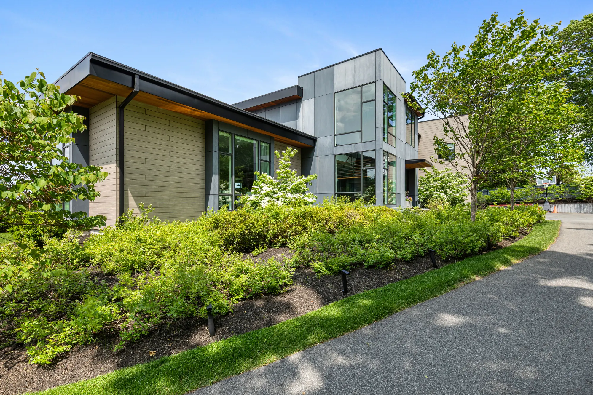 The side of the house above planted banks along the curving drive.