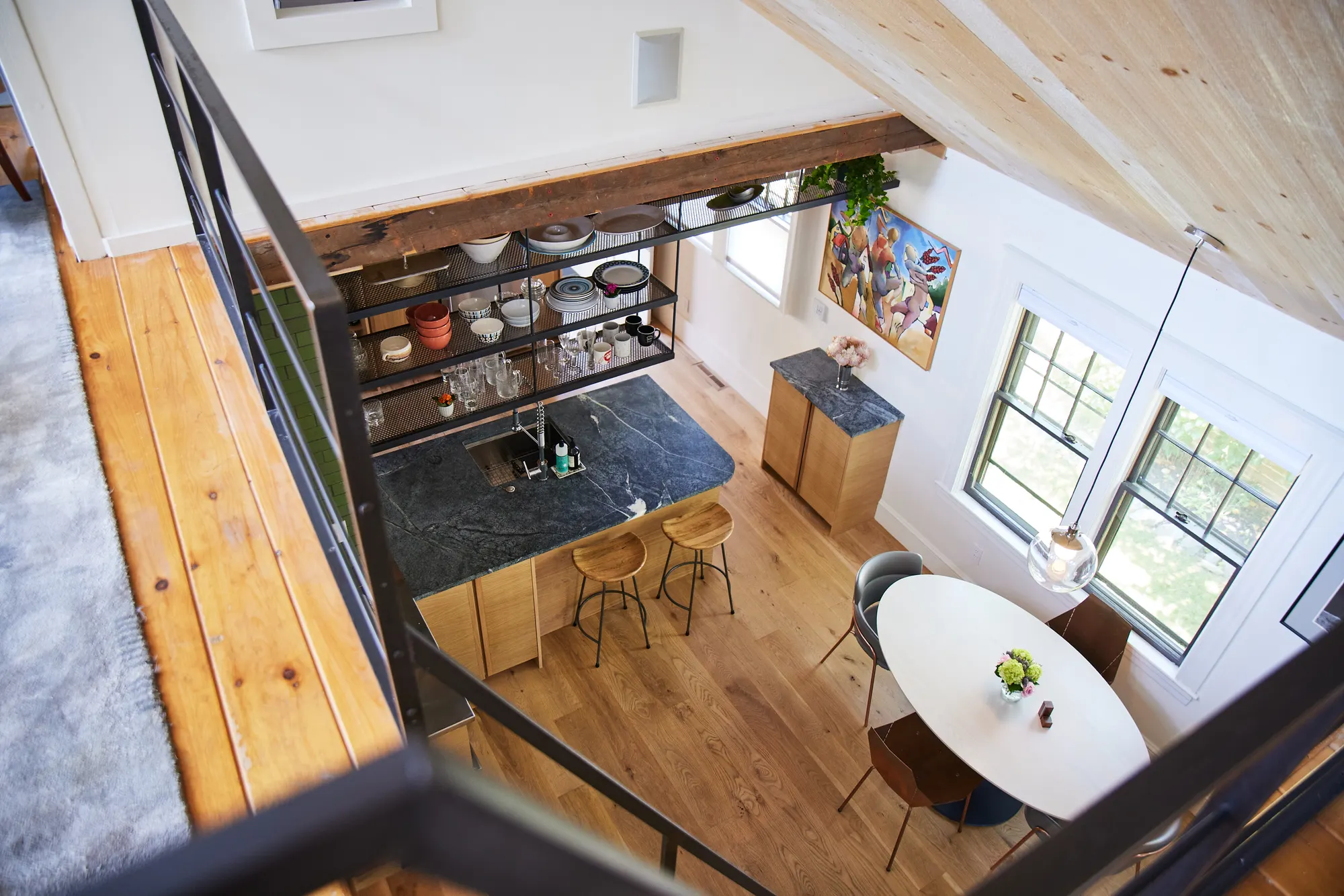 The kitchen's soapstone counter and stools and the dining table, seen from the loft.